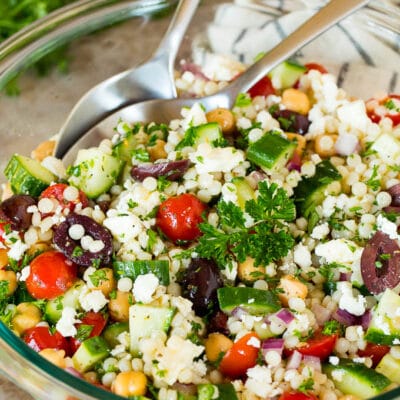 A bowl of couscous salad garnished with parsley.