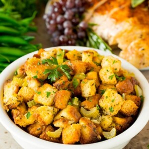 A bowl of crock pot stuffing topped with fresh herbs.
