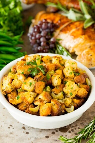 A bowl of crock pot stuffing topped with fresh herbs.