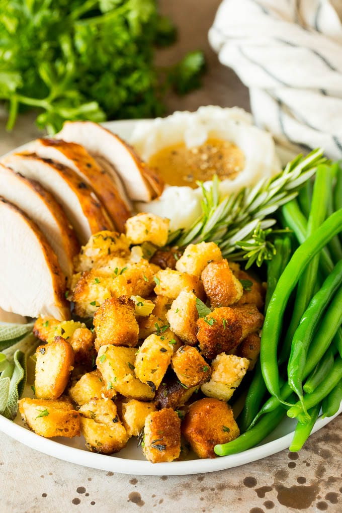 Crock pot stuffing on a plate with turkey, green beans and mashed potatoes.