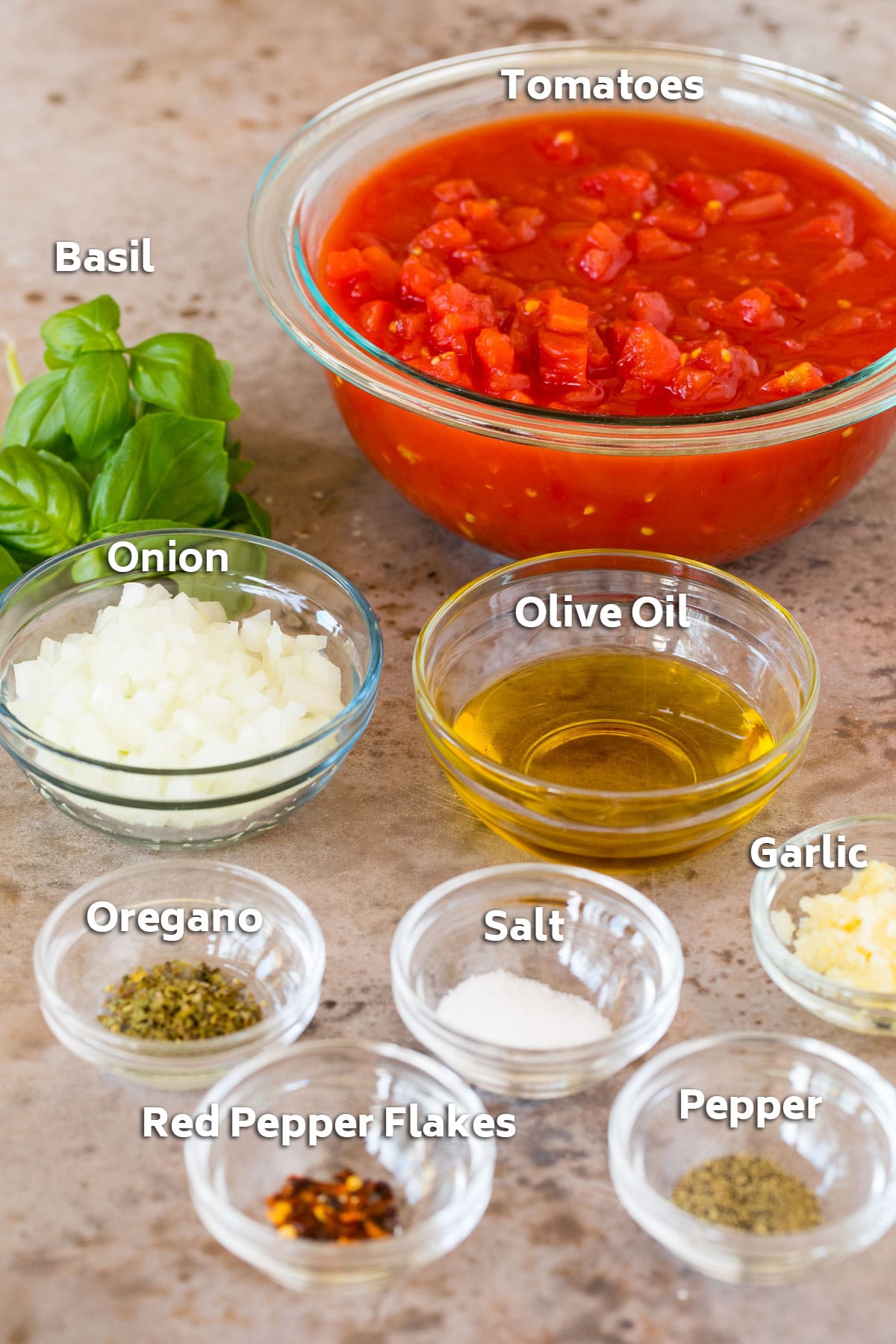 Bowls of ingredients including tomatoes, olive oil, vegetables and herbs.