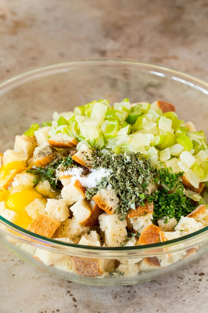 A bowl of bread cubes with eggs, bread and vegetables.