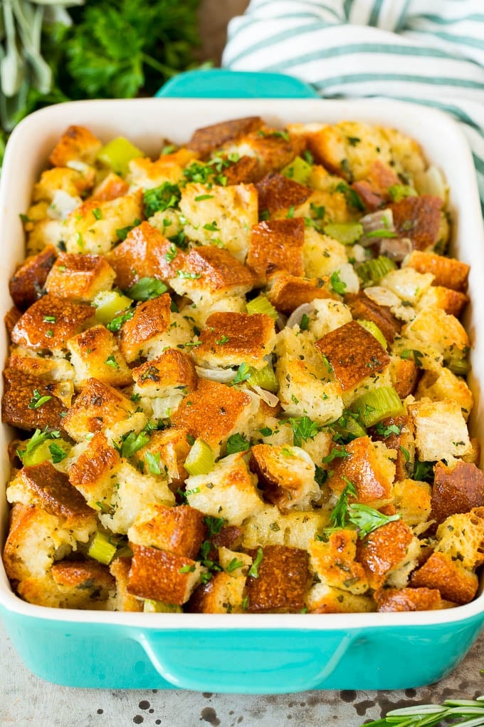 This Thanksgiving stuffing is a mixture of bread cubes, vegetables and plenty of herbs, all baked together until golden brown. Thanksgiving stuffing in a baking dish, topped with parsley.