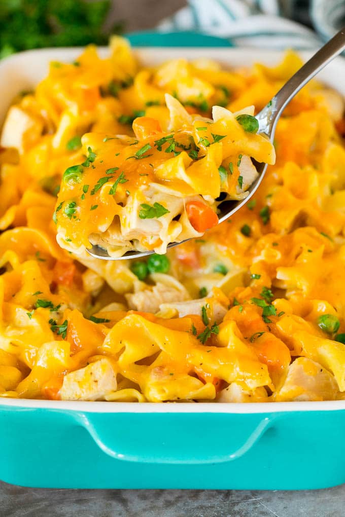 A spoon serving up a portion of cheesy turkey casserole.