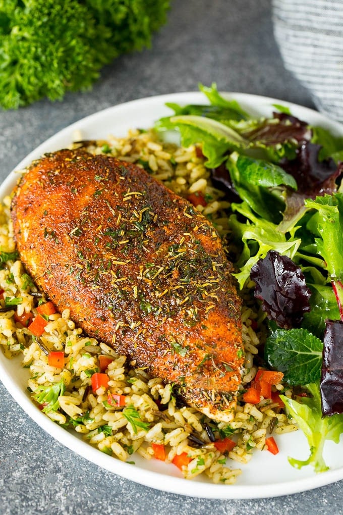 Chicken seasoning on a cooked chicken breast, served with rice and salad.