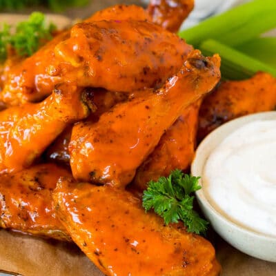 Air fryer chicken wings coated in buffalo sauce and served with ranch and celery.