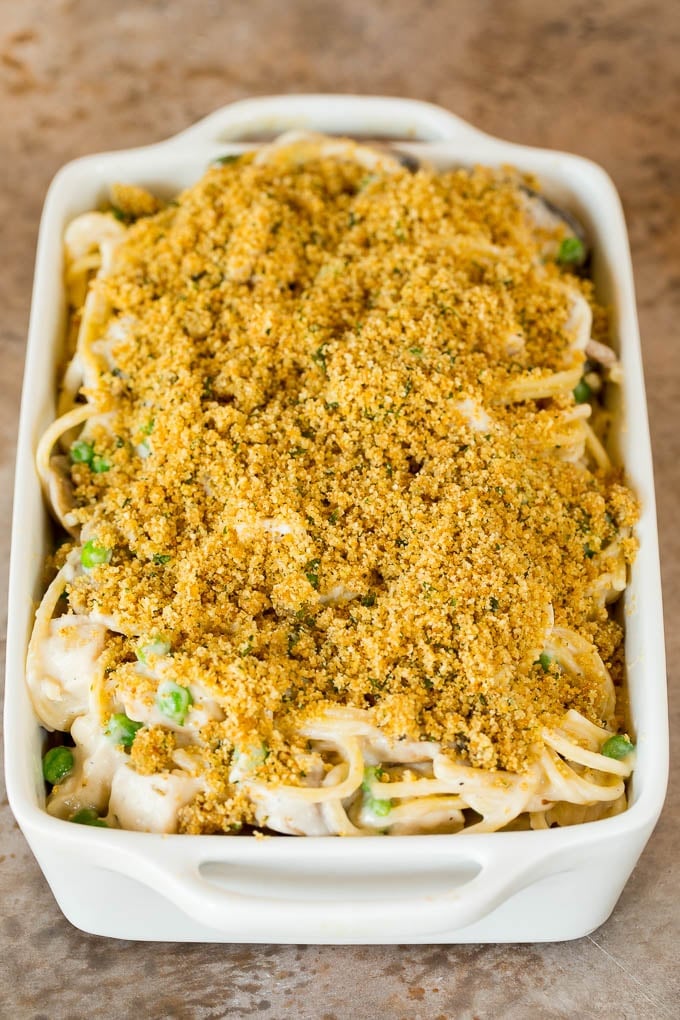 A casserole dish of creamy spaghetti with breadcrumbs on top.