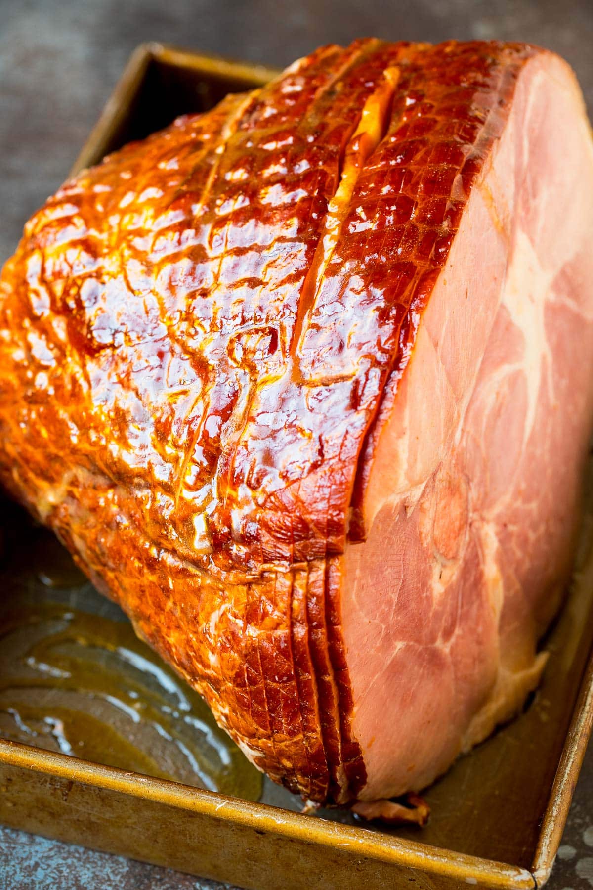 A ham in a baking dish covered in glaze.