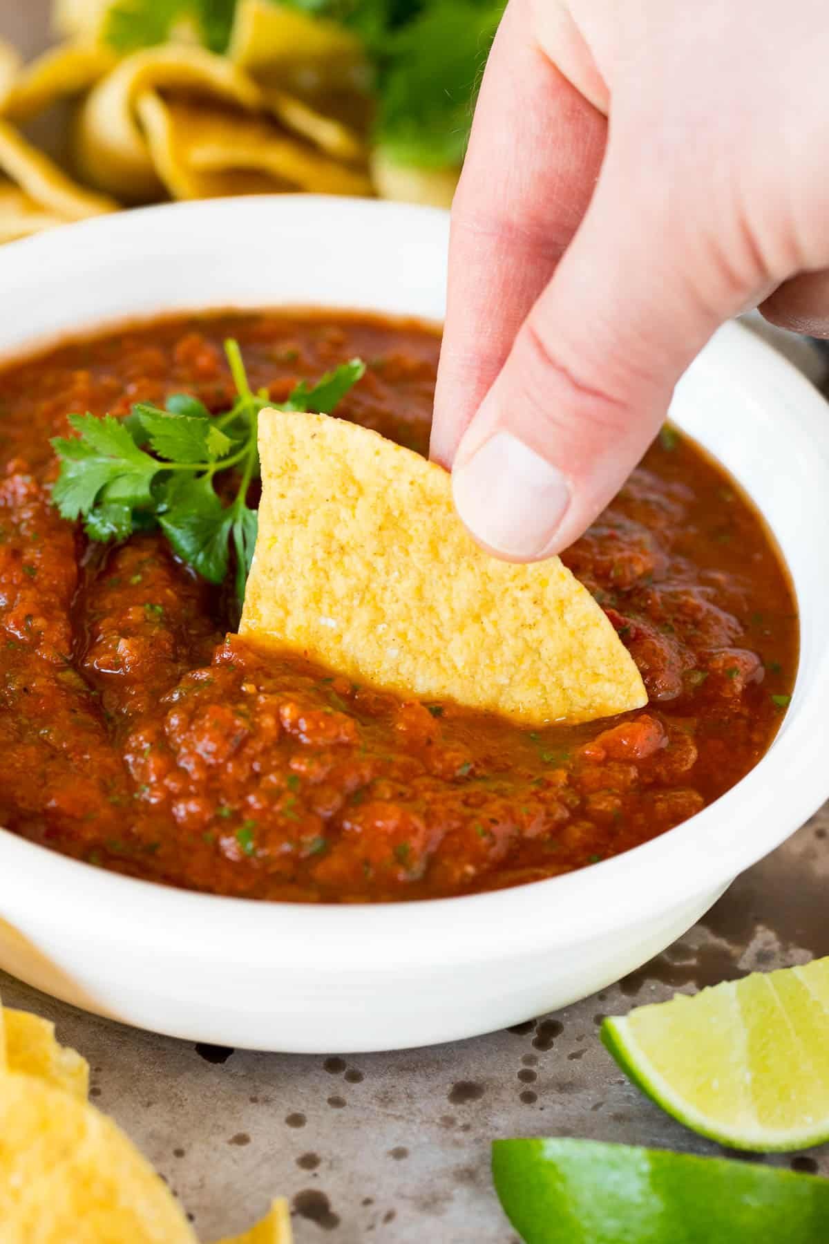 A chip scooping up a serving of tomato salsa.