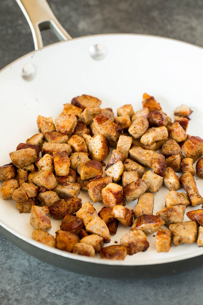 Seared pork pieces in a skillet.