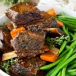 A serving bowl of slow cooker short ribs and green beans.