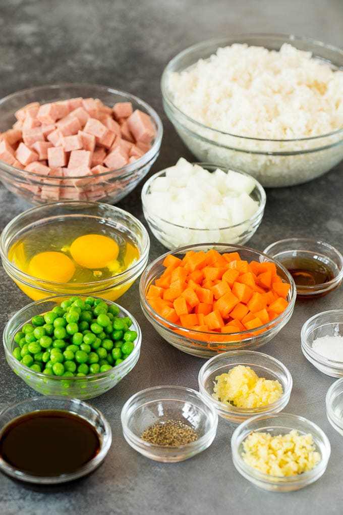 Bowls of ingredients including spam, rice, vegetables and seasonings.