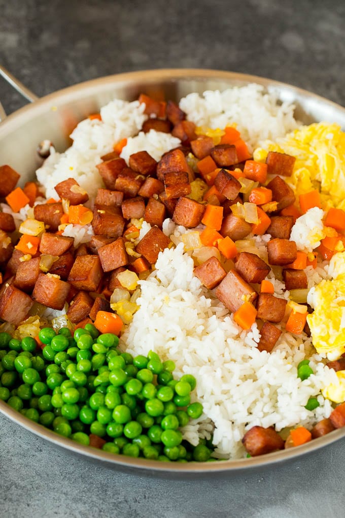 A pan of rice, fried eggs, vegetables and Spam.
