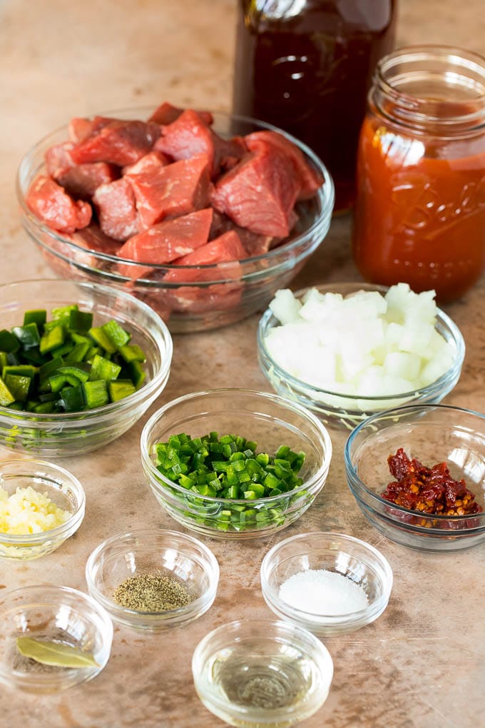 Bowls of ingredients including beef, peppers, onions and spices.