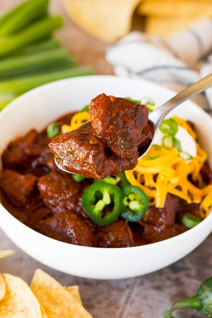 A spoon holding up a serving of Texas chili.