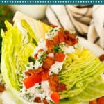 This wedge salad recipe is chunks of iceberg lettuce topped with homemade blue cheese dressing, bacon, tomatoes and chives.