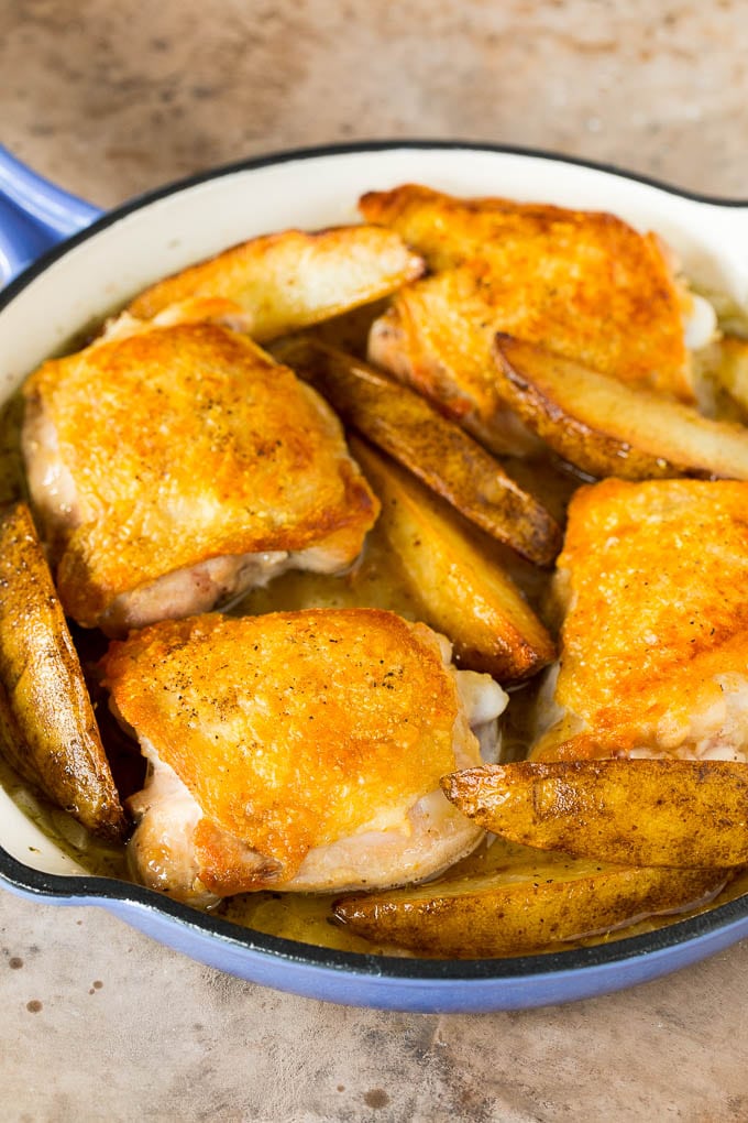 Chicken thighs, potatoes, broth and seasonings in a pan.