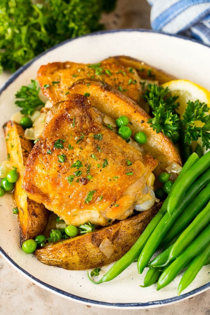 A plate of chicken Vesuvio served with green beans.