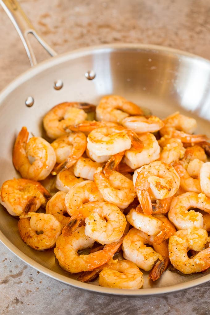 Cooked shrimp in a metal pan.