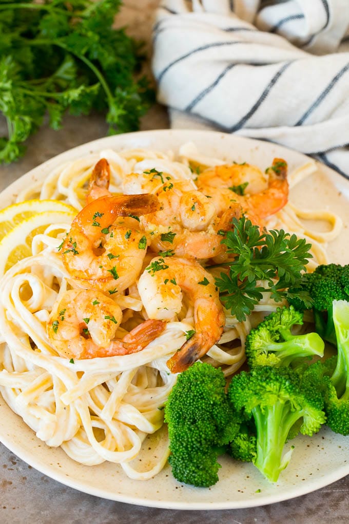 A plate of shrimp linguine served with broccoli.