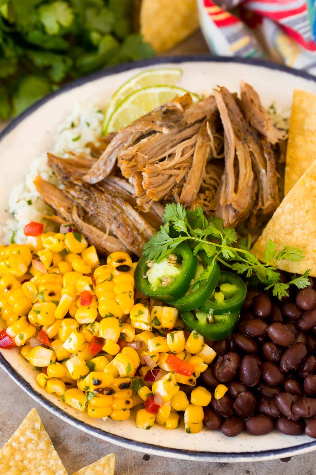 Corn salsa on a plate with rice, beans and pork.
