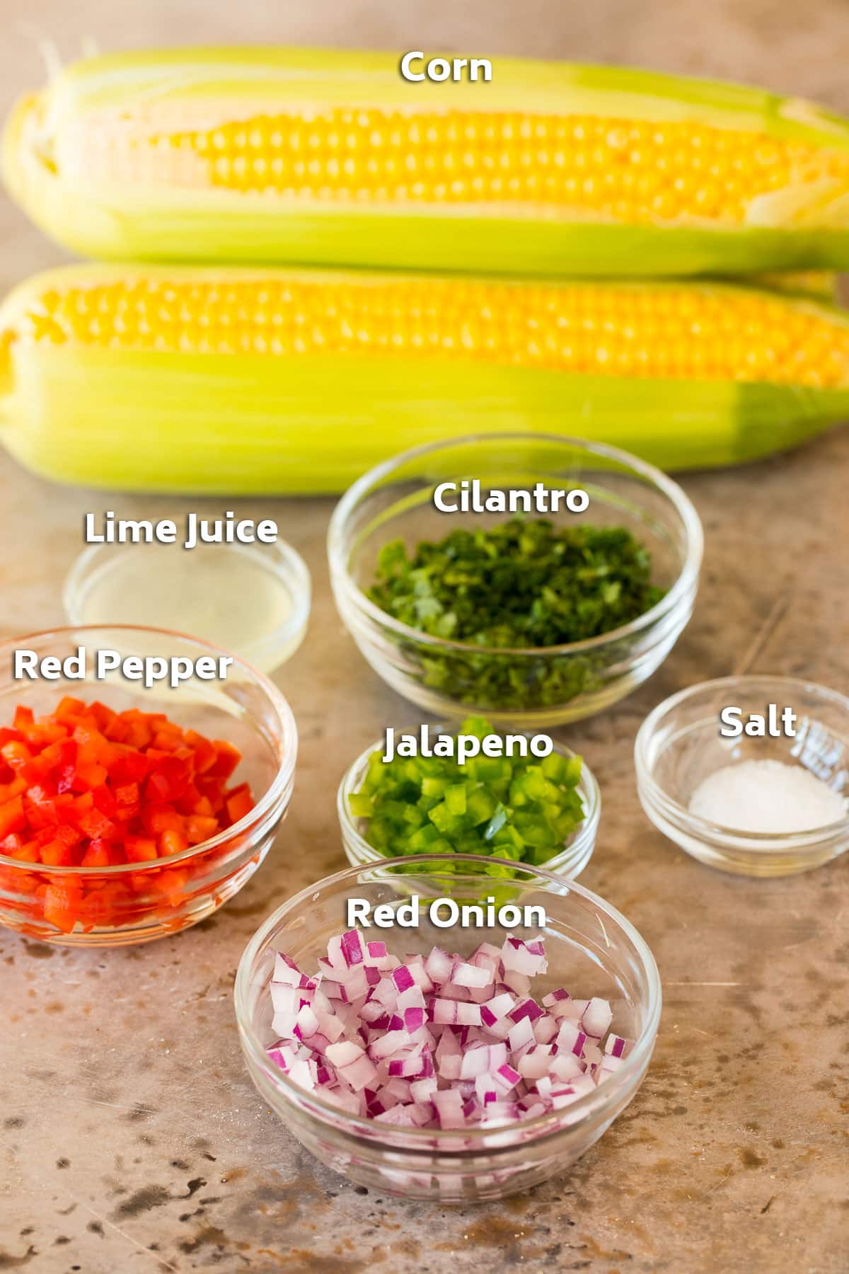 Ingredients including corn on the cob, peppers and onions.