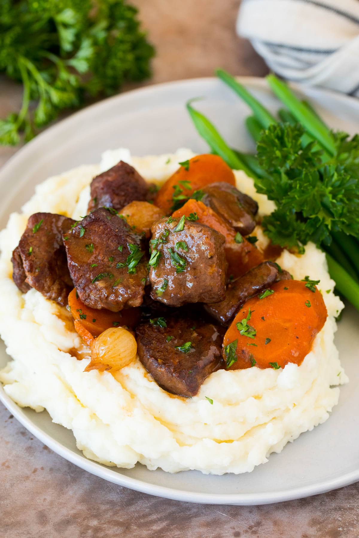 Beef served over a pile of make ahead mashed potatoes.