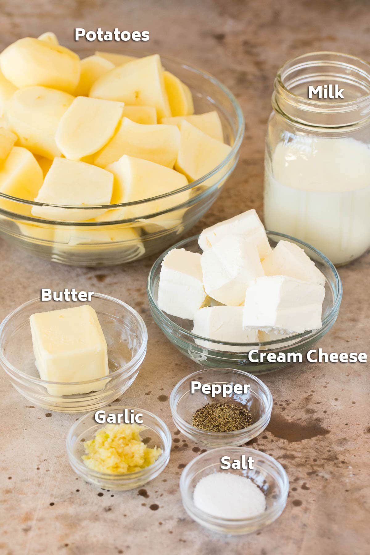 Bowls of potatoes, cream cheese, butter and seasonings.