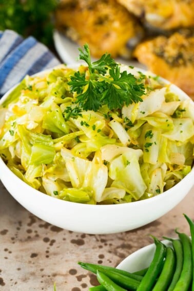 A bowl of sauteed cabbage served with chicken and green beans.