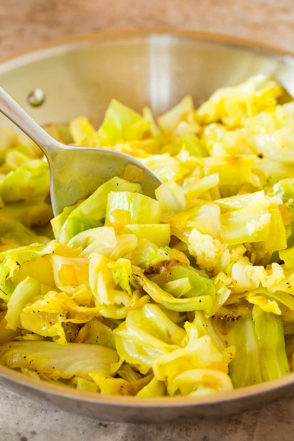 A pan of cooked vegetable with a spoon in it.