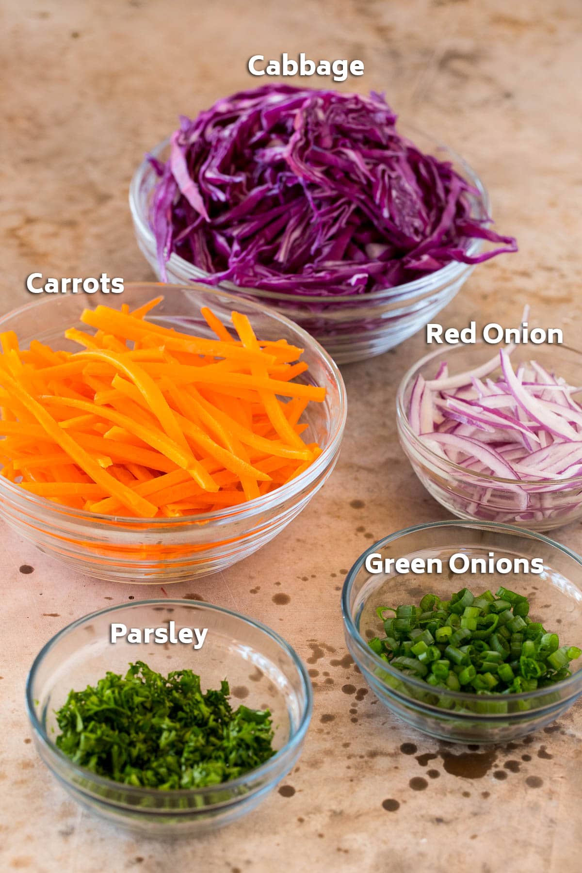 Bowls of shredded vegetables and chopped herbs.