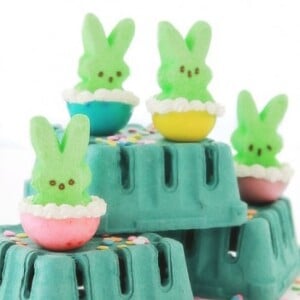 Peeps Jello shots with green peeps sitting on egg cups.