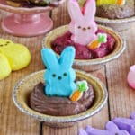 Bunny peeps sitting in small pie crusts filled with chocolate..