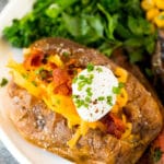 Air fryer baked potatoes served with steak and vegetables.