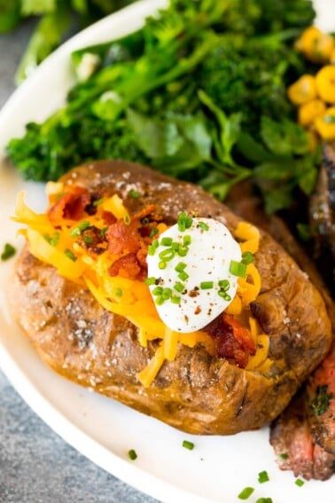 Air fryer baked potatoes served with steak and vegetables.