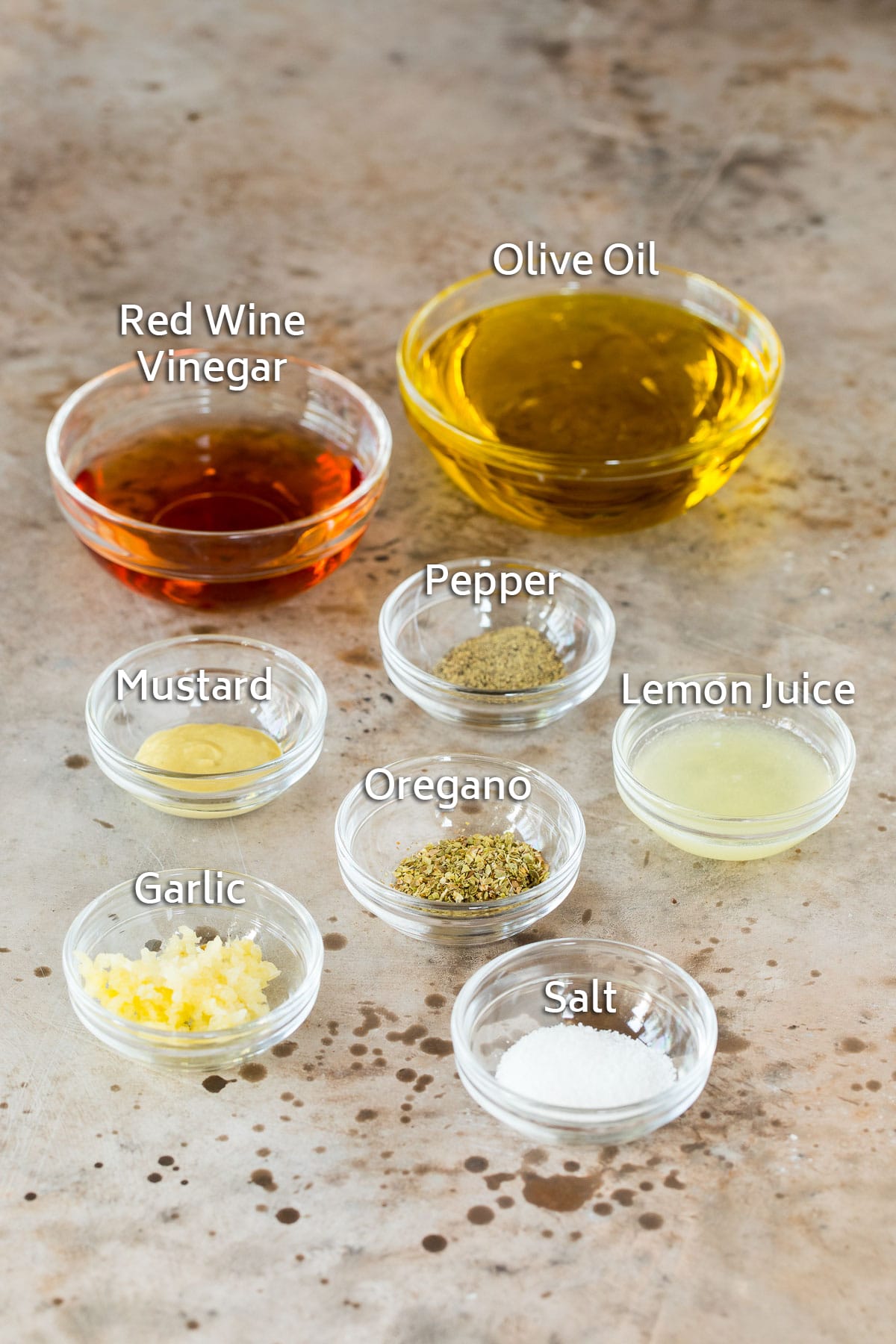 Bowls of ingredients including olive oil, vinegar, lemon juice and seasonings.