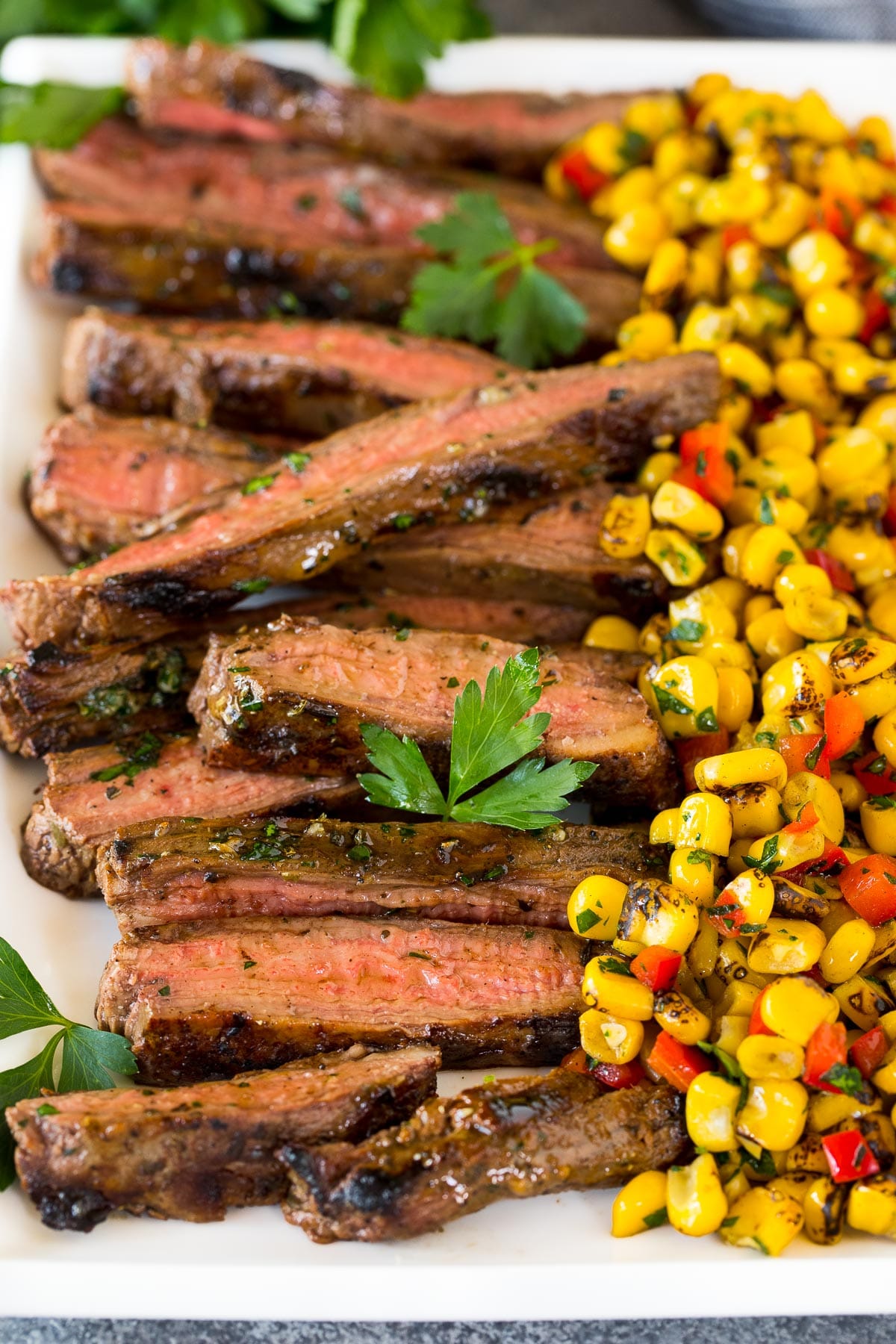 Sliced grilled flank steak on a platter.