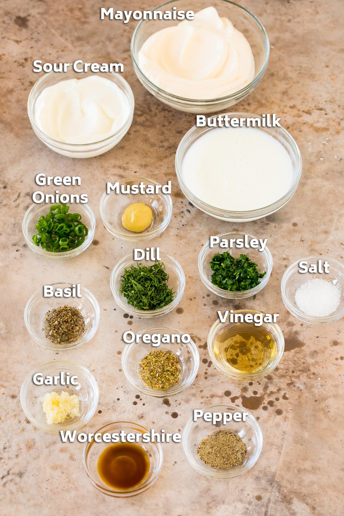 Bowls of ingredients including mayonnaise, sour cream, buttermilk and herbs.