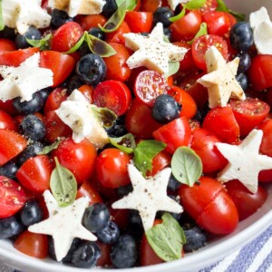An image of a bowl of caprese salad with blueberries and cherry tomatoes.