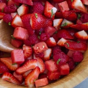 An image of fruit salad featuring red fruits like strawberries, raspberries and watermelon.