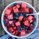 An image of a bowl of fruit salad with berries and watermelon.