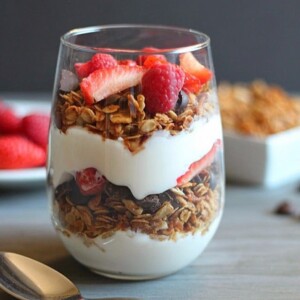 An image of granola yogurt parfait with berries in a clear glass.