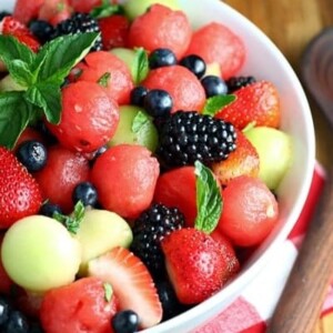 An image of fruit salad with berries and melon balls.