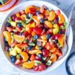 A picture of a fruit salad with grapes, blueberries and other colorful fruit.