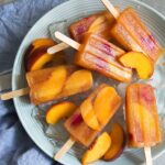 A picture of a bowl with raspberry, peach sangria popsicles.
