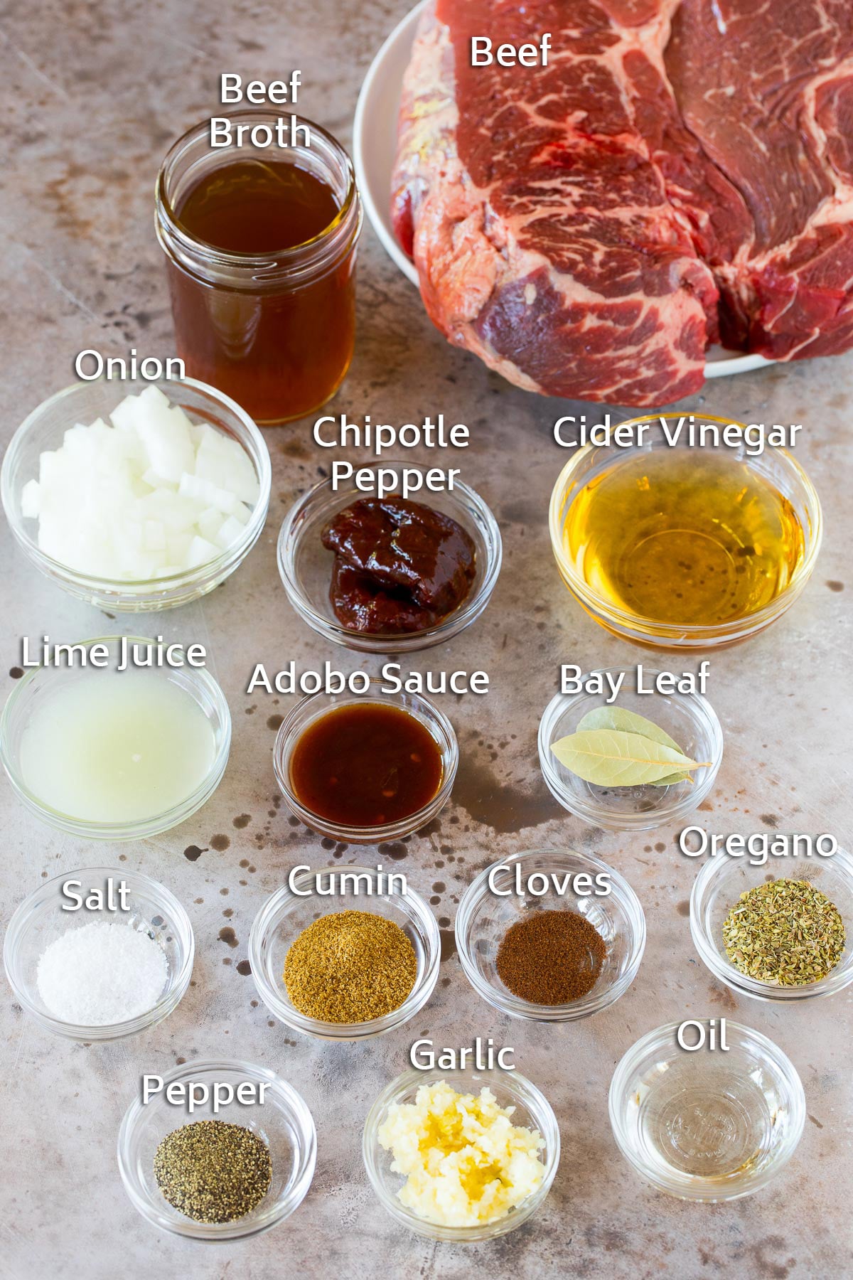 Bowls of different spices and seasonings, and a beef roast.