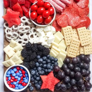 An image of a charcuterie board with berries, cheeses, and meats.