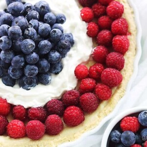 An image of a round tart decorated with blueberries and raspberries.