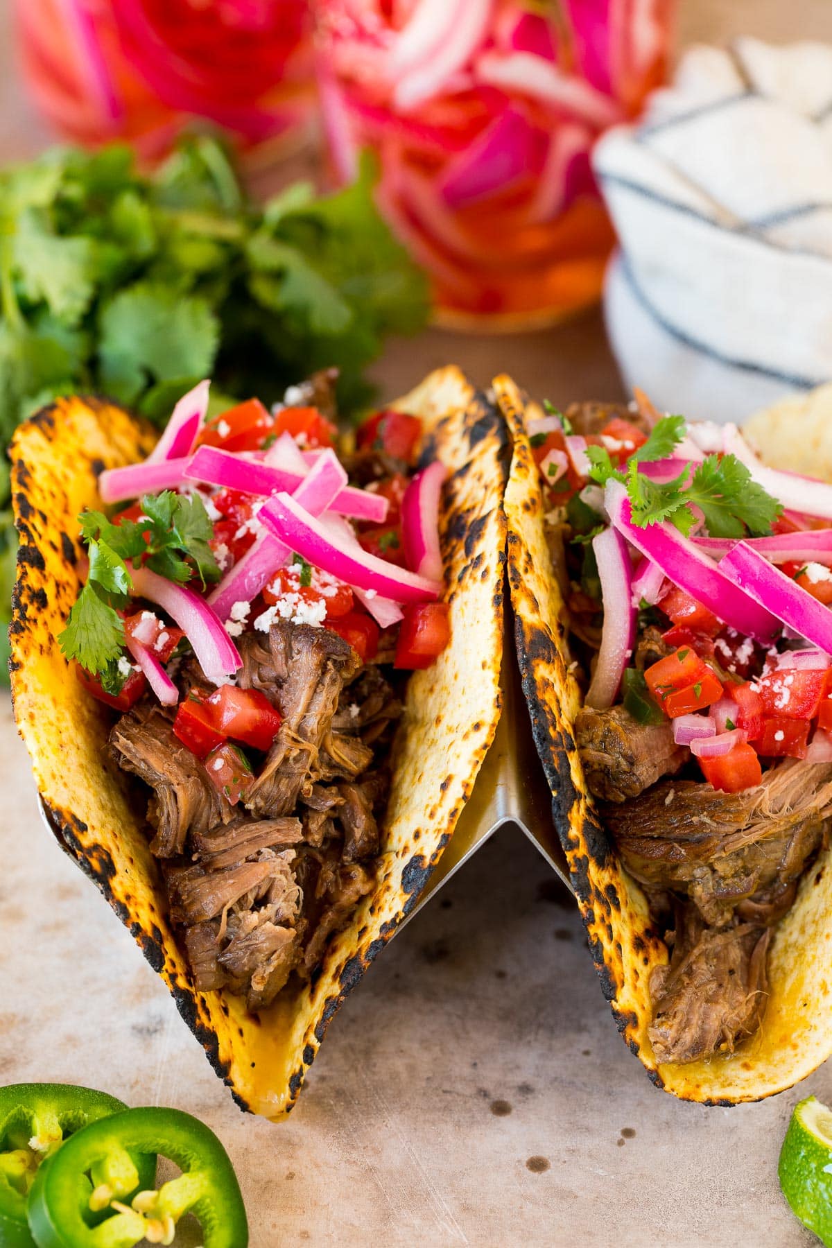 Tacos topped with pickled red onions.