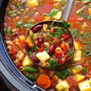 An image of a ladle full of slow cooker minestrone soup.